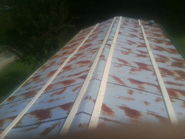 Rusted metal roof panels with new wood purlins before replacement — Storm Damage Roof Repair in Homer by Roofing Brothers
